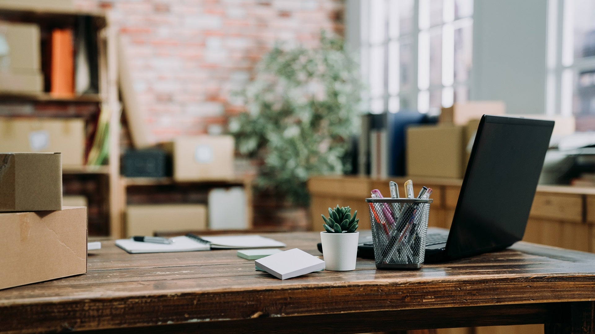 Büro im Loft Stil, mit Schreibtisch, Laptop, Regalen und Kartons